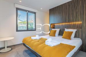 a bedroom with a large bed with yellow sheets and pillows at Easy Clés - Villa Jacuzzi Pool AC in Saint-Jean-de-Luz