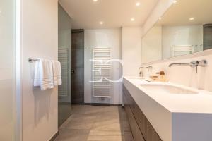a white bathroom with a sink and a mirror at Easy Clés - Villa Jacuzzi Pool AC in Saint-Jean-de-Luz