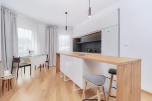 una cucina con armadi bianchi, tavolo e sedie di Two Level Apartment 2WATERS by Renters a Breslavia