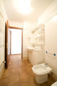 a white bathroom with a sink and a toilet at Residence Campo Smith in Bardonecchia