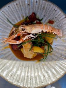 a plate of food with a shrimp on top at Glewstone Court Country House Hotel in Ross on Wye