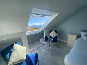 a bedroom with a bed and a table and a window at SeaClusion Barna in Barna