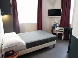 ein Schlafzimmer mit Bett, Schreibtisch und Fernseher in der Unterkunft Hotel Alnea in Cannes + 14 Fotos