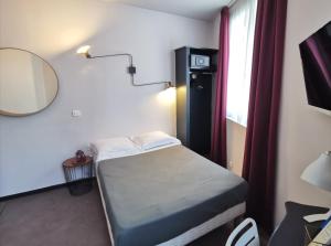 Cette petite chambre comprend un lit et une lampe. dans l'établissement Hotel Alnea, à Cannes