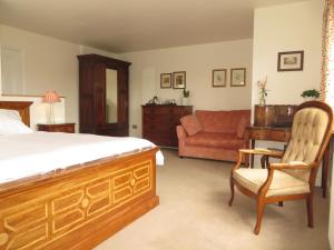 1 dormitorio con cama, escritorio y sofá en The Lawns B & B en Budleigh Salterton