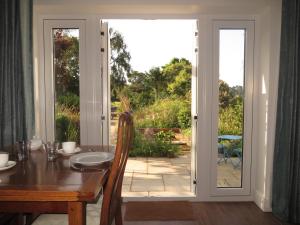 uma sala de jantar com uma mesa e uma porta de vidro deslizante em The Lawns B & B em Budleigh Salterton