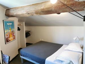 - une chambre avec un lit et une poutre en bois dans l'établissement Hotel Alnea, à Cannes