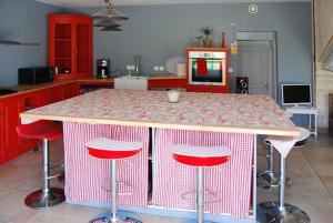 a kitchen with a table with four stools around it at Maison luxueuse Louargat, jardin B in Louargat +5 photos