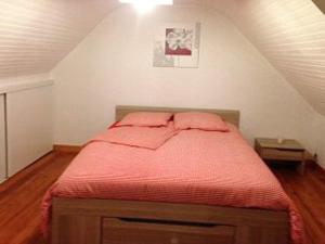 a bedroom with a red bed in the attic at Maison luxueuse Louargat, jardin B in Louargat