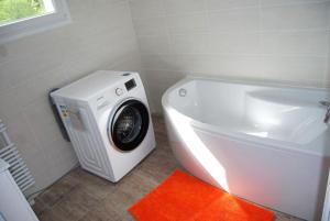 a white bathroom with a washing machine next to a sink at Maison luxueuse Louargat, jardin B in Louargat
