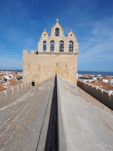 un bâtiment avec une tour au sommet d'un mur dans l'établissement Ref LS64: Maison 4-6 pers Les Hameaux de Camargue, à Saintes-Maries-de-la-Mer