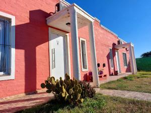ein rotes Gebäude mit einem Kaktus davor in der Unterkunft Cabaña La Nena in Santa Rosa