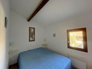 une chambre avec un lit bleu et une fenêtre dans l'établissement Ref LS64: Maison 4-6 pers Les Hameaux de Camargue, à Saintes-Maries-de-la-Mer