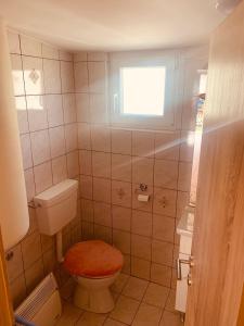 een kleine badkamer met een toilet en een raam bij Bungalow Perun in Blejska Dobrava