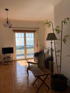 a living room with a couch and a chair and a plant at Páteo na Ericeira in Ericeira