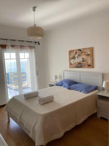 1 dormitorio con 1 cama con 2 toallas en Páteo na Ericeira, en Ericeira