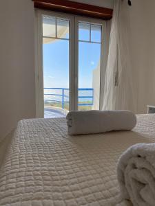 a bedroom with a bed with a view of the ocean at Páteo na Ericeira in Ericeira