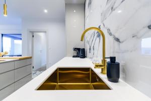 a kitchen with a gold sink and white counters at Luxury penthouse Marina - Sukošan in Sukošan +41 photos