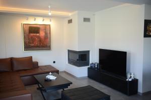 uma sala de estar com um sofá e uma televisão de ecrã plano em Luxury Villa Plaka Litochoro em Plaka Litochorou