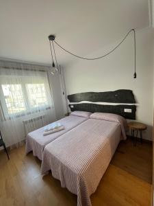 1 dormitorio con 1 cama con 2 toallas en ENTRECAMIÑOS, en O Pedrouzo