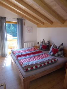 a bedroom with a large bed with pillows on it at Feriendorf Via Claudia Haus 78 Platzhirsch in Lechbruck