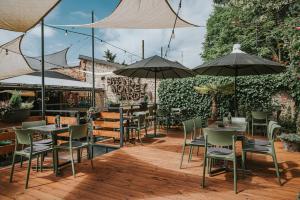 eine Terrasse mit Tischen, Stühlen und Sonnenschirmen in der Unterkunft Stay Swanky Hostel in Zagreb