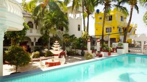 a hotel with a swimming pool in front of a building at White & Yellow Castle Hotel and Resort in Balibago