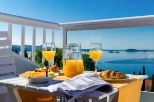 - une table avec deux verres de jus d'orange et de pain dans l'établissement Apartments Knego, à Mlini