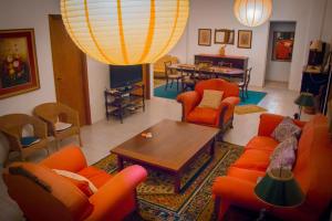 Hotel Solar dos Tchuccos في أوروغويانا: غرفة معيشة مع كراسي برتقالية وطاولة