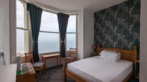 a bedroom with a bed and a large window at Areawest in Scarborough
