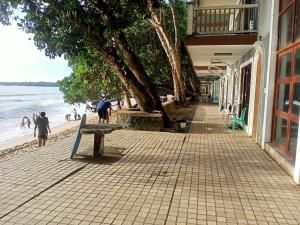 un banco en una acera junto a la playa en Lippo Carita Selatan en Carita
