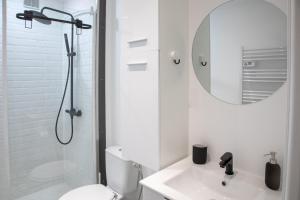 a white bathroom with a shower and a sink at Studio Royal - 10 minutes to Monaco in Roquebrune-Cap-Martin