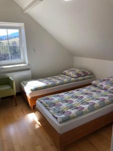 sypialnia z dwoma łóżkami i oknem w obiekcie Domek w Gaiku w Limanowej