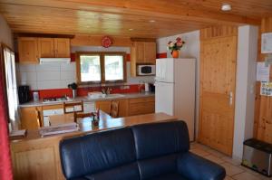 a kitchen with a white refrigerator and a black couch at le velan in Giez