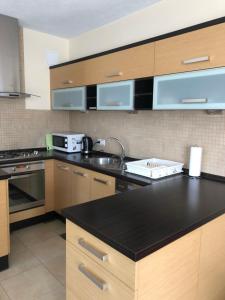 a kitchen with wooden cabinets and a black counter top at Domek w Gaiku in Limanowa