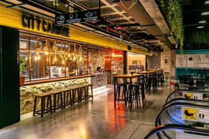 a restaurant with a bar with stools and tables at WI-FI 350MB | Foodhall | 450m do Shopping #CA14 in Florianópolis