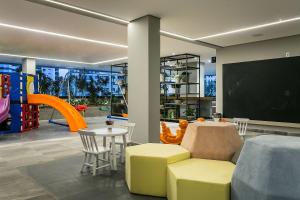 a play room with a table and chairs and a chalkboard at WI-FI 350MB | Foodhall | 450m do Shopping #CA14 in Florianópolis