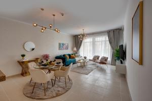 een woonkamer met een tafel en een bank bij Durrani Homes - Modern Living at Burj Views in Dubai