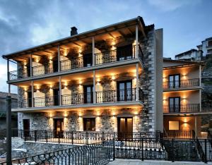 duży kamienny budynek z oświetleniem w obiekcie Lagadia 4 Seasons Hotel w mieście Lagkadia