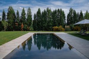レッジェッロにあるVIESCA Suites & Villas Il Borro Toscanaの傘付きの庭のスイミングプール