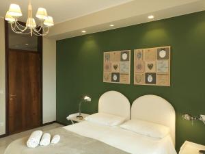 レッジョ・ディ・カラブリアにあるVilla Annaの緑のベッドルーム(白い枕2つ付きのベッド1台付)