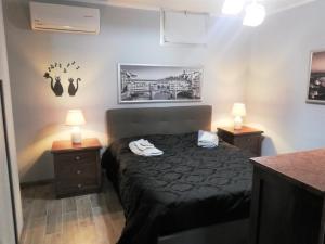 ein Schlafzimmer mit einem Bett mit zwei Nachttischen und zwei Lampen in der Unterkunft La Taverna Appartamento Scala a Chiocciola in Follonica