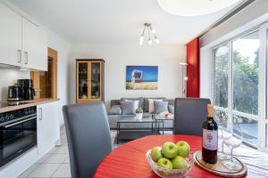 uma cozinha e sala de estar com uma mesa com uma garrafa de vinho em Gorch-Fock Park 2 em Timmendorfer Strand