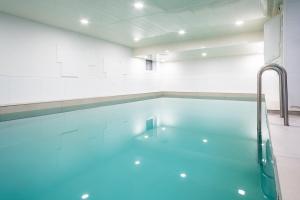 a swimming pool with blue water in a room at Hotel Haus am Park in Borkum