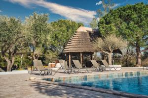 a group of chairs and a gazebo next to a pool at Mas De Calabrun in Saintes-Maries-de-la-Mer