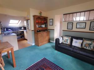 a living room with a couch and a kitchen at Rose Cottage, Meathop Grange in Grange Over Sands