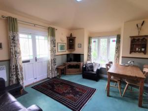 a living room with a table and a couch at Rose Cottage, Meathop Grange in Grange Over Sands