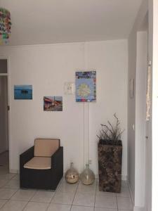 a room with a chair and a clock on the wall at Studio lumineux avec vue sur la mer à Capesterre, 20 m², terrasse in Capesterre