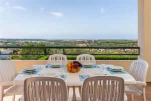 a white table with chairs and a bowl of fruit on it at Casa Campo in Loulé