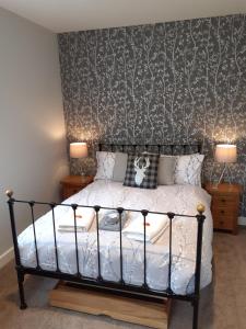 um quarto com uma cama, 2 candeeiros e uma parede em The Kemps Guest House em Inverness